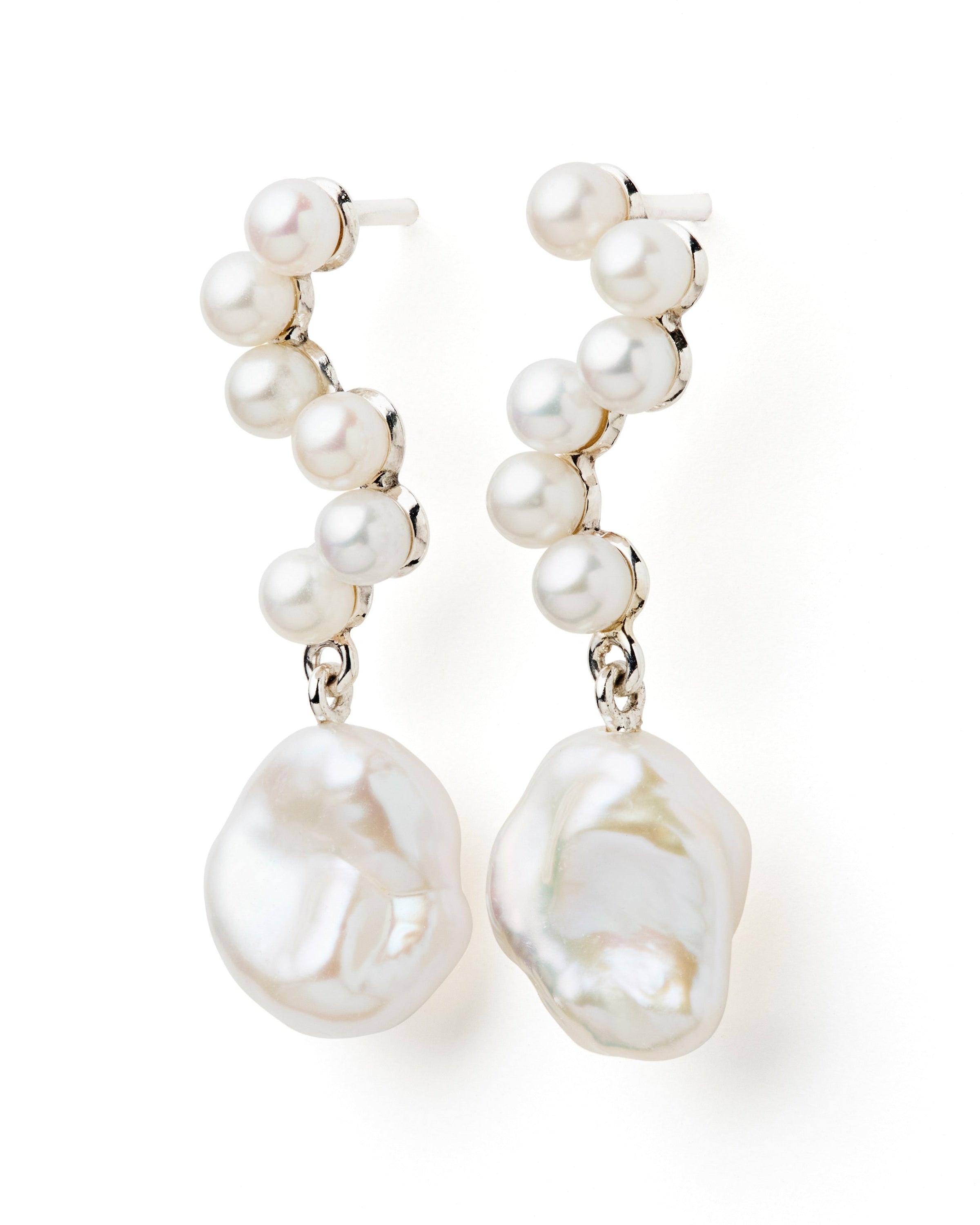 A pair of silver earrings featuring white freshwater pearls in a dangle style.
