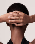 A person with a sun glitter ring on their finger, with the rest of the hand and arm outstretched.